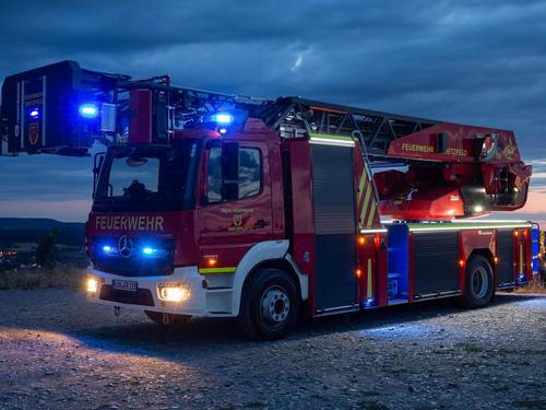 Feuerwehrauto mit angeschaltetem Blaulicht bei Nacht