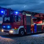 Feuerwehrauto mit angeschaltetem Blaulicht bei Nacht